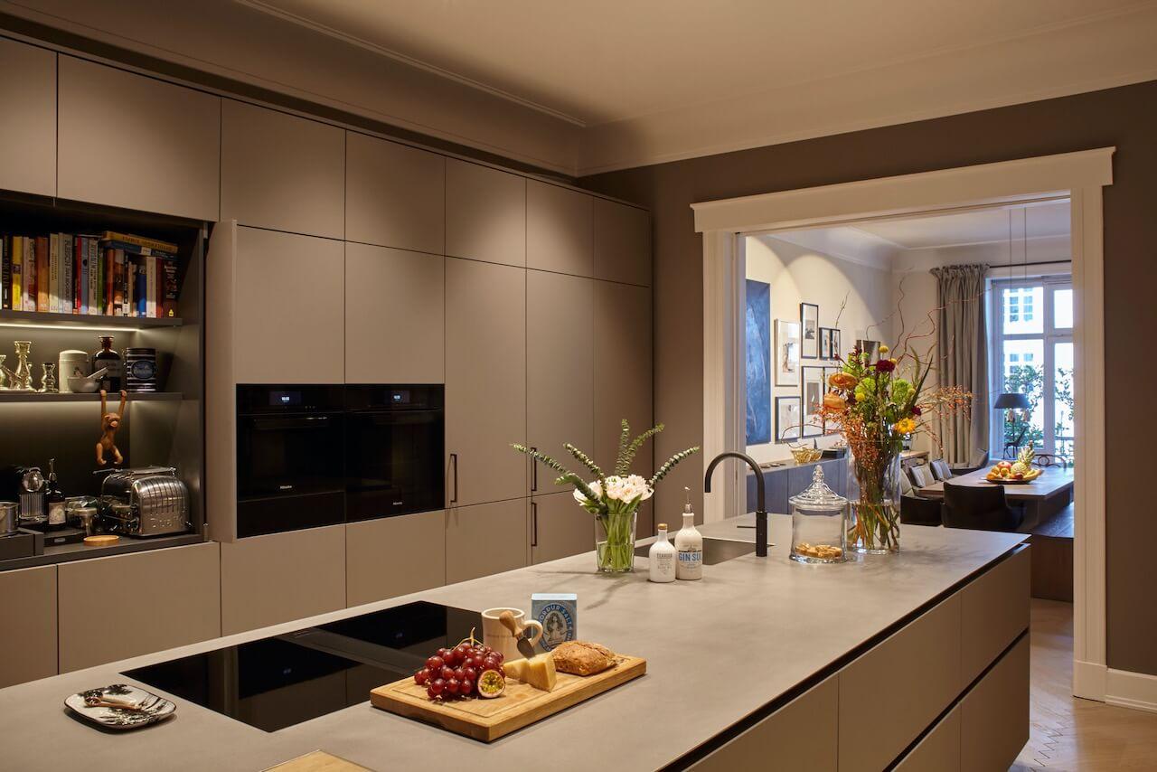 Luxe keuken in taupe met inbouwapparatuur en stenen werkblad