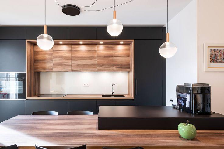 Moderne keuken met zwarte kasten, houten wandnis en kookeiland